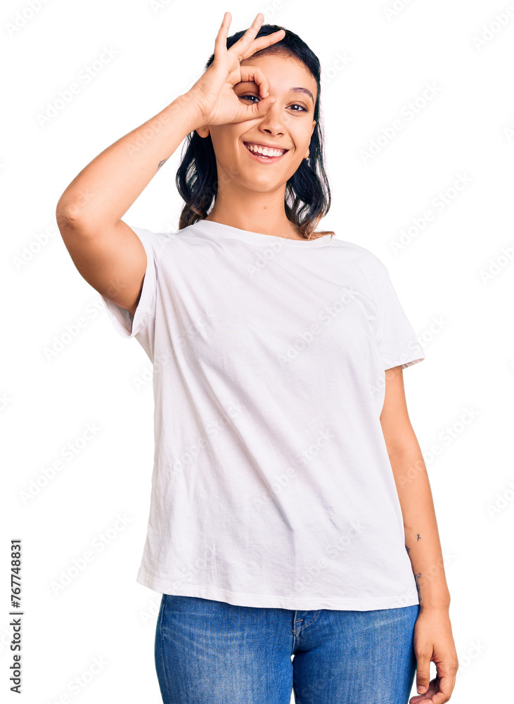 Young woman wearing casual clothes doing ok gesture with hand smiling, eye looking through fingers with happy face. Young woman wearing casual clothes doing ok gesture with hand smiling, eye looking through fingers with happy face.
