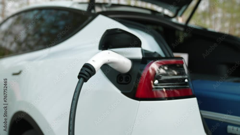 Couple recharge their EV car with electric battery charging station at ...