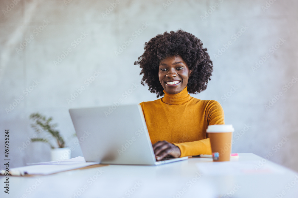 Portrait of smiling African American business woman looking at camera standing in modern office. Successful business and career concept. Successful businesswoman. Portrait of smiling African American business woman looking at camera standing in modern office. Successful business and career concept. Successful businesswoman.