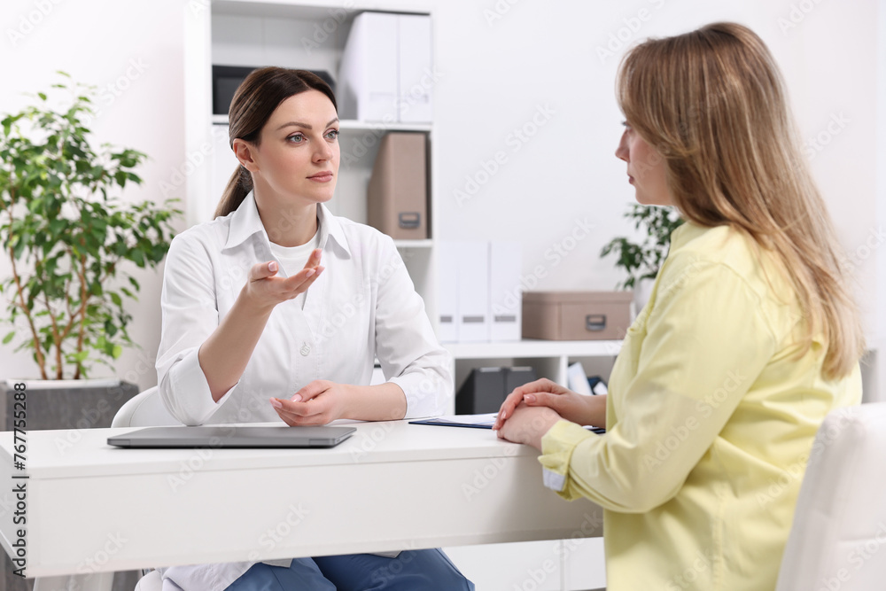 Mammologist consulting woman during appointment in hospital Mammologist consulting woman during appointment in hospital