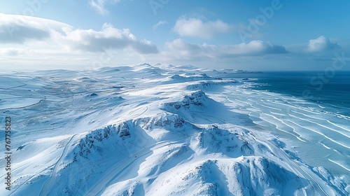 A view of rolling hills covered in white snow, with paths made by visitors, offers a sense of silence and peace.