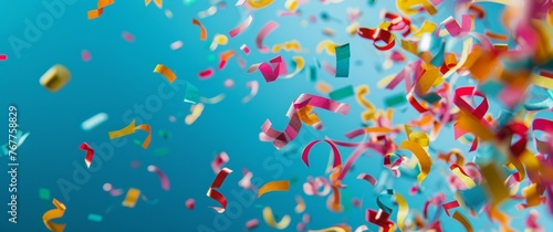 Colorful confetti falling on a blue background with copy space for a celebration or party design. Happy new year, anniversary or birthday concept.