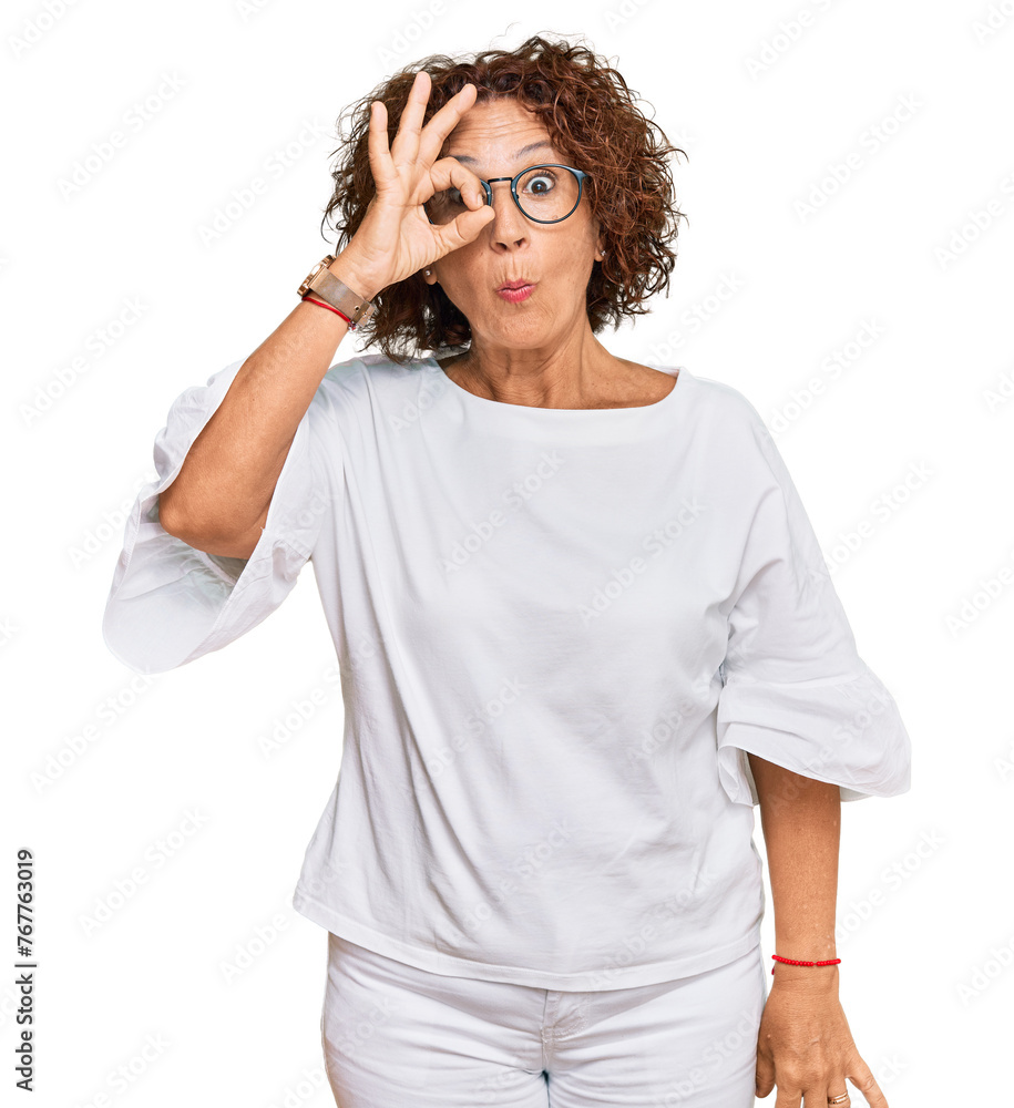Beautiful middle age mature woman wearing casual clothes and glasses doing ok gesture shocked with surprised face, eye looking through fingers. unbelieving expression. Beautiful middle age mature woman wearing casual clothes and glasses doing ok gesture shocked with surprised face, eye looking through fingers. unbelieving expression.