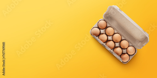 Overhead view of brown chicken eggs in an open egg carton isolated on white photo