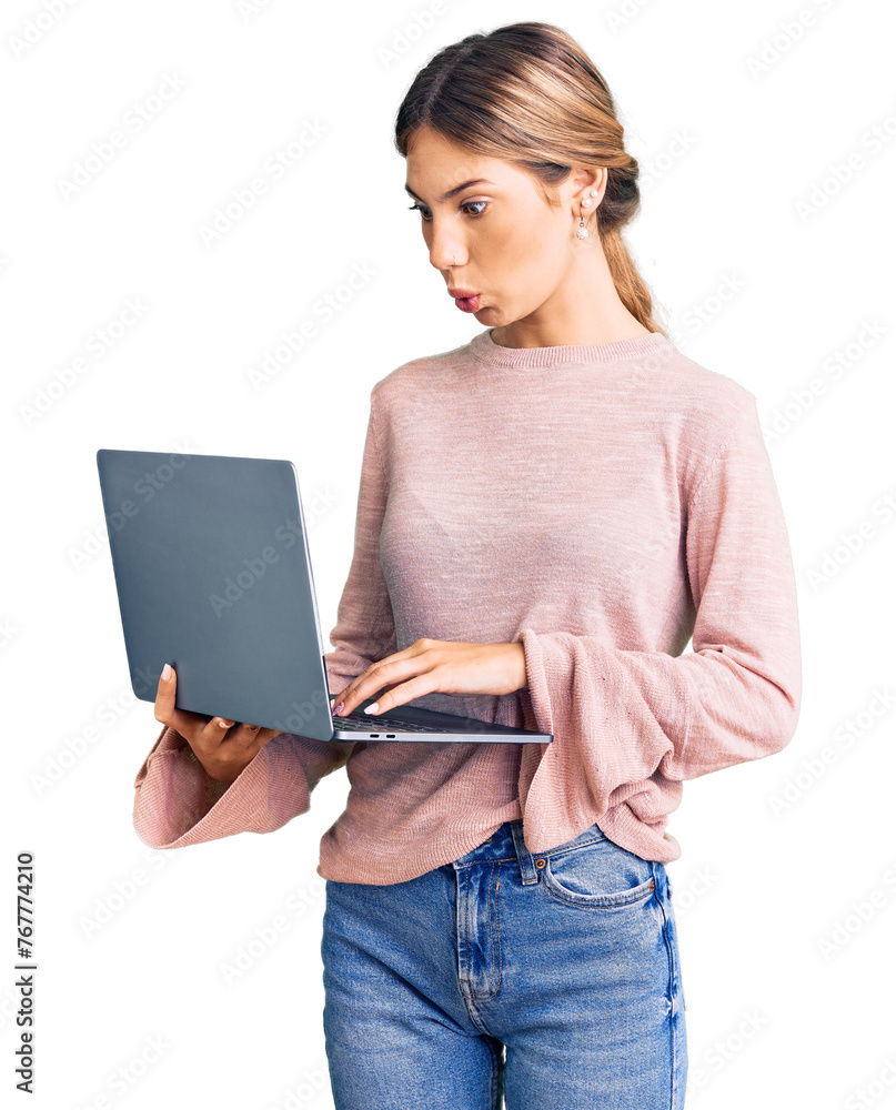 Beautiful caucasian woman with blonde hair working using computer laptop scared and amazed with open mouth for surprise, disbelief face Beautiful caucasian woman with blonde hair working using computer laptop scared and amazed with open mouth for surprise, disbelief face