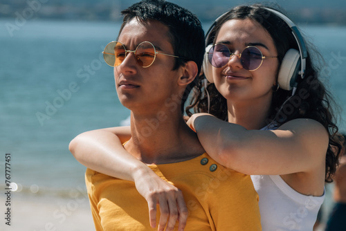 relaxed young couple with headphones enjoying on the beach photo