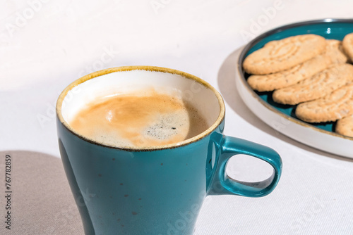 Fresh Coffee in a Blue Mug Beside Crispy Cookies on a Sunny Day