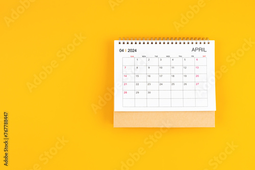 April 2024 desk calendar on yellow color background, position with copy space.