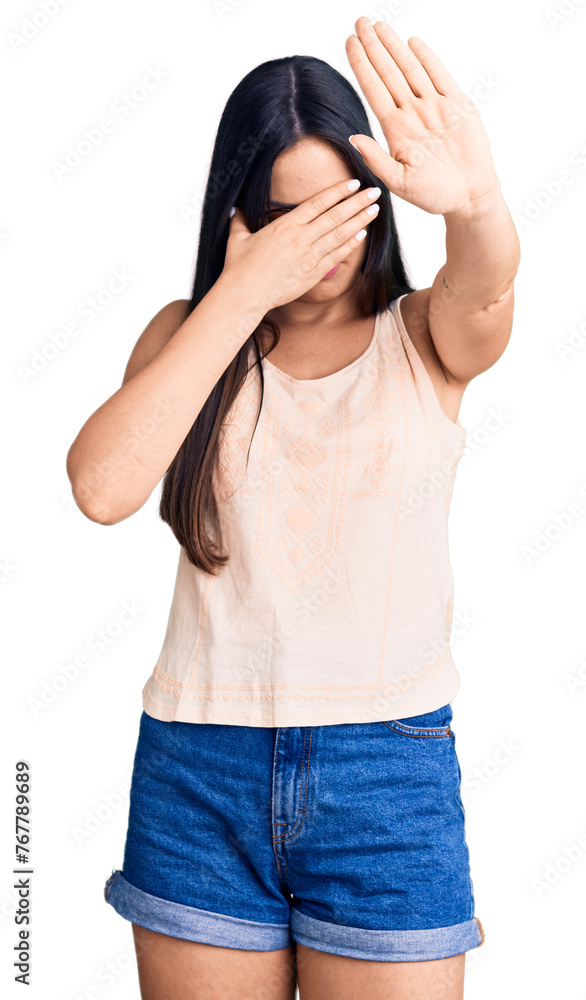 Young beautiful caucasian woman wearing casual clothes and glasses covering eyes with hands and doing stop gesture with sad and fear expression. embarrassed and negative concept. Young beautiful caucasian woman wearing casual clothes and glasses covering eyes with hands and doing stop gesture with sad and fear expression. embarrassed and negative concept.