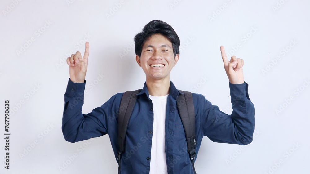Young handsome Asian man is happy pointing upwards Young handsome Asian man is happy pointing upwards