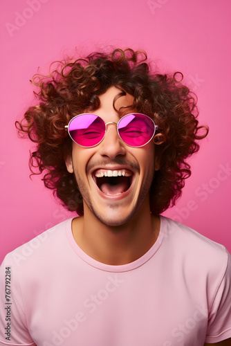 Young man with curly hair wearing pink sunglasses on pink background  © jimenezar