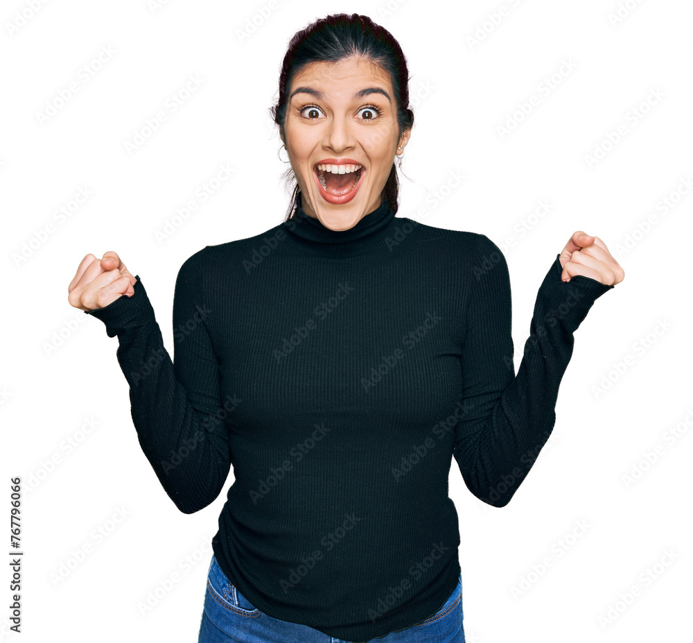 Young hispanic woman wearing casual clothes celebrating surprised and amazed for success with arms raised and open eyes. winner concept. Young hispanic woman wearing casual clothes celebrating surprised and amazed for success with arms raised and open eyes. winner concept.