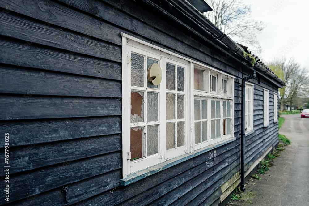 Old English wooden former Inn now derelict in a village location. The ...