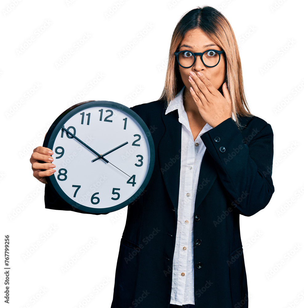 Young hispanic woman holding big clock covering mouth with hand, shocked and afraid for mistake. surprised expression Young hispanic woman holding big clock covering mouth with hand, shocked and afraid for mistake. surprised expression