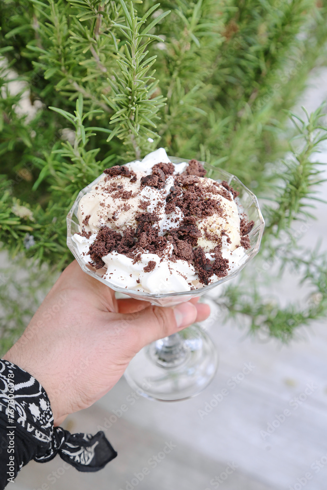 Person Holding a Dessert in Their Hand at a Restaurant Table Person Holding a Dessert in Their Hand at a Restaurant Table
