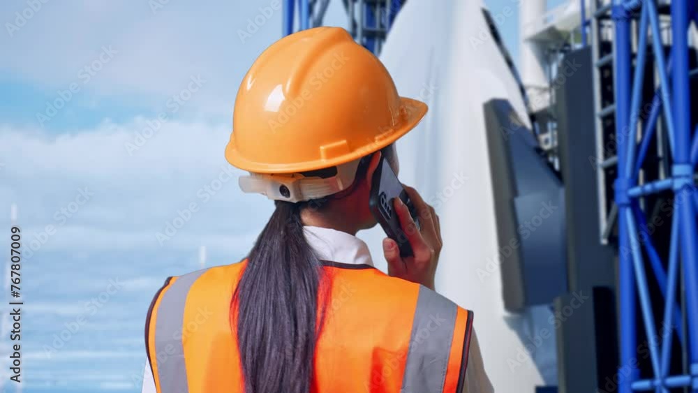 Close Up Back View Of Asian Female Engineer With Safety Helmet Talking On Smartphone While Standing With Space Shuttle Close Up Back View Of Asian Female Engineer With Safety Helmet Talking On Smartphone While Standing With Space Shuttle