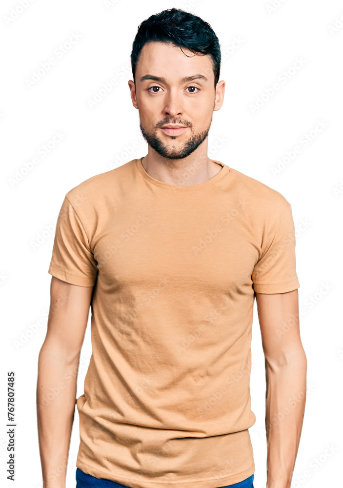 Hispanic man with beard wearing casual t shirt relaxed with serious expression on face. simple and natural looking at the camera. Hispanic man with beard wearing casual t shirt relaxed with serious expression on face. simple and natural looking at the camera.