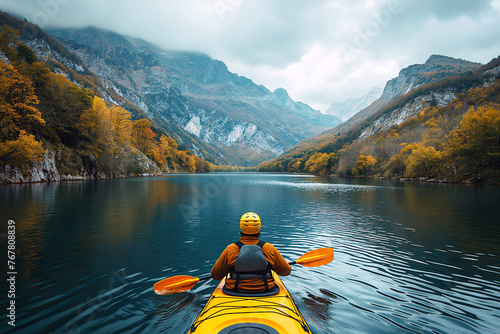 back of kayaker kayaking on lake with a landscape of mountain and forests in nature © alexkoral
