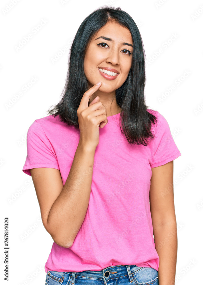 Beautiful asian young woman wearing casual pink t shirt looking confident at the camera with smile with crossed arms and hand raised on chin. thinking positive. Beautiful asian young woman wearing casual pink t shirt looking confident at the camera with smile with crossed arms and hand raised on chin. thinking positive.