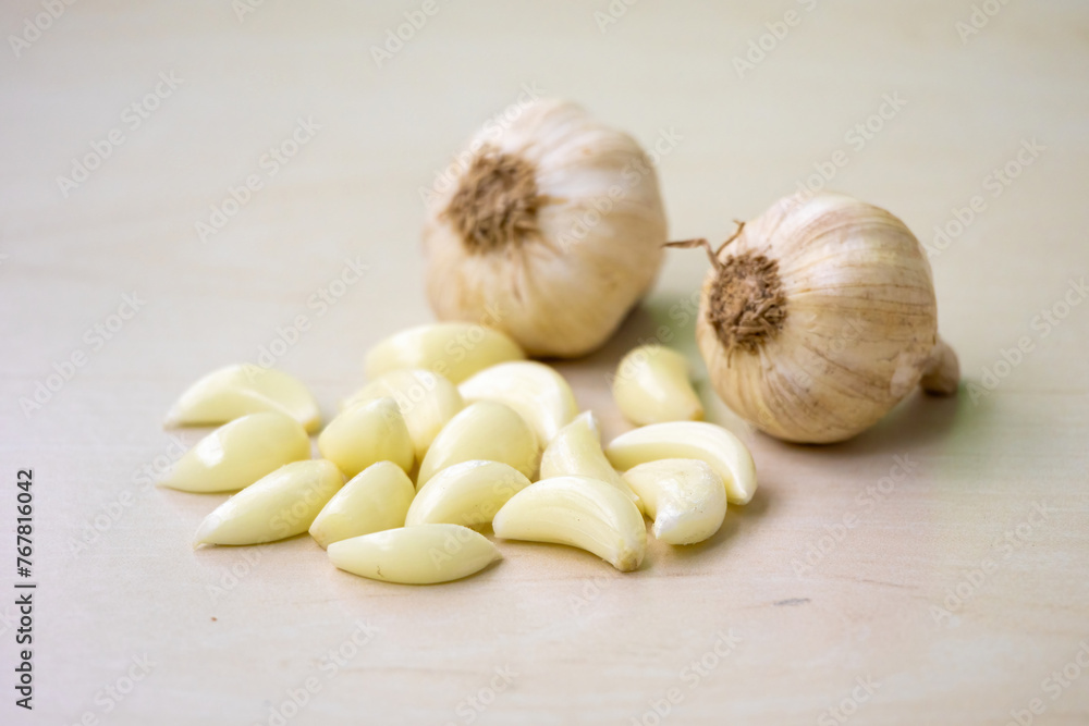 Fresh garlic cloves and whole garlic isolated on a wooden background. Its scientific name is Allium sativum. Locally in Bangladesh, it is called Rosun. Fresh garlic cloves and whole garlic isolated on a wooden background. Its scientific name is Allium sativum. Locally in Bangladesh, it is called Rosun.
