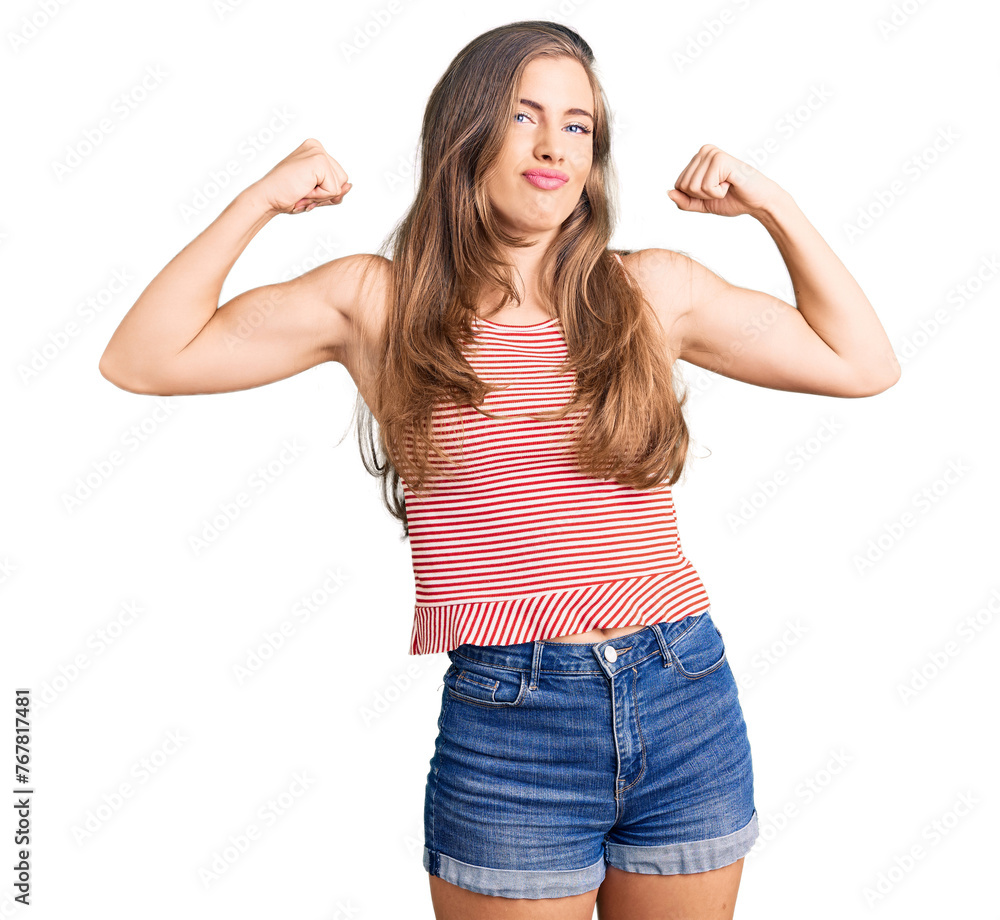 Beautiful caucasian young woman wearing casual clothes showing arms muscles smiling proud. fitness concept. Beautiful caucasian young woman wearing casual clothes showing arms muscles smiling proud. fitness concept.