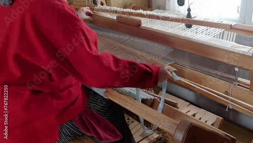 Detail of a woman using a handmade loom weaving cotton. Craft concept.Gammelstad, Sweden photo