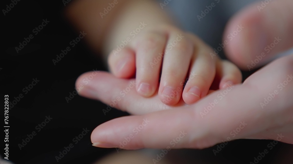 mother holds the hand of a newborn. children hand. hospital takes care of happy family medicine concept. newborn baby holding mom hand close-up. mom takes care close-up baby in the hospital mother holds the hand of a newborn. children hand. hospital takes care of happy family medicine concept. newborn baby holding mom hand close-up. mom takes care close-up baby in the hospital