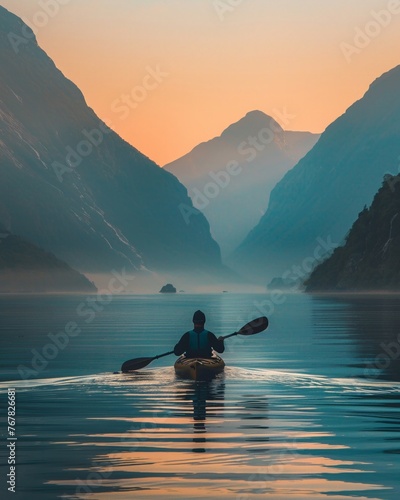 Adventurer navigating a kayak through tranquil waters at dawn