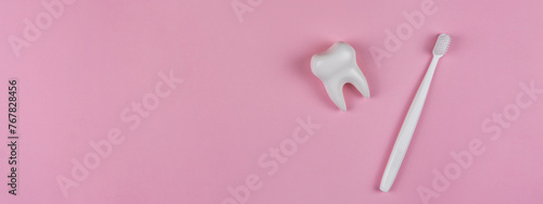 Healthy white tooth and toothbrush on a pink background. The concept of dentistry, health, health care, oral care. Oral hygiene, professional teeth cleaning. Banner for a dental clinic, copy space