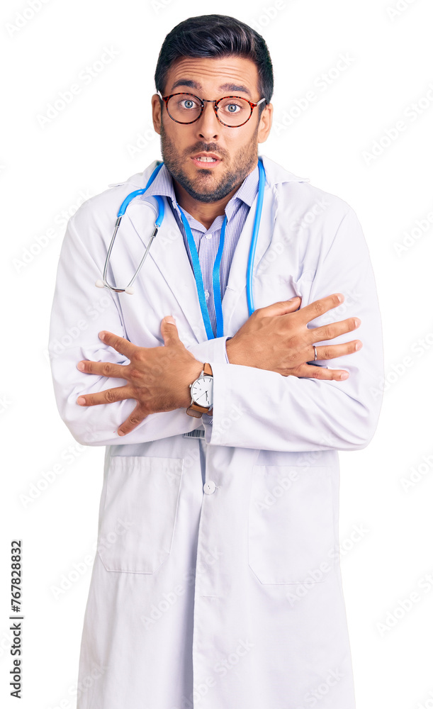 Young hispanic man wearing doctor uniform and stethoscope shaking and freezing for winter cold with sad and shock expression on face Young hispanic man wearing doctor uniform and stethoscope shaking and freezing for winter cold with sad and shock expression on face