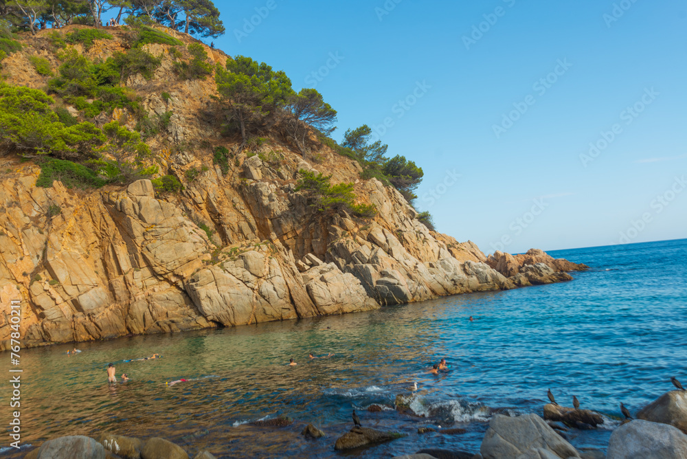 TOSSA DE MAR, CATALONIA, SPAIN: A beautiful small beach between the mountains with rocks near the fortress