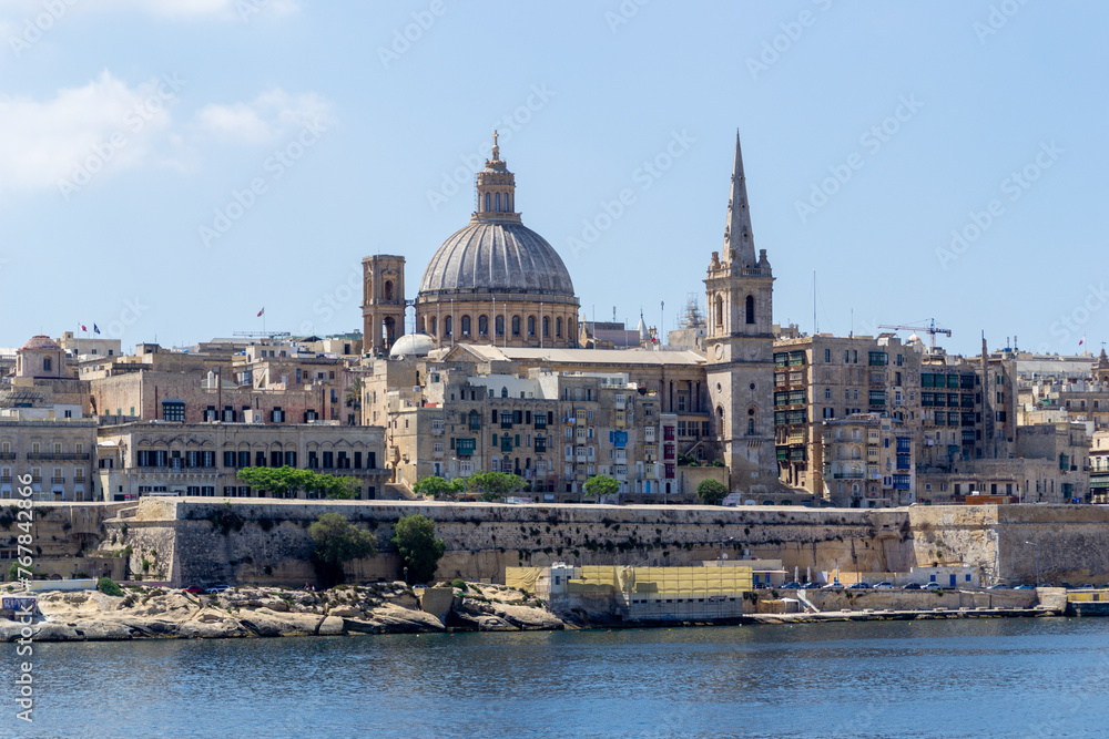 Valletta, Malta - June 9th 2016: The fortified capital city Valletta with the dome of Basilica of Our Lady of Mount Carmel and the tower of Saint Paul's Pro-Cathedral overlooking  Marsamxett Harbour.