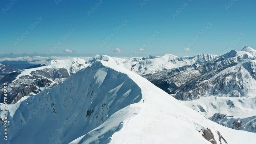 Snow-capped mountain peaks under a clear blue sky, panoramic shot in bright daylight Snow-capped mountain peaks under a clear blue sky, panoramic shot in bright daylight