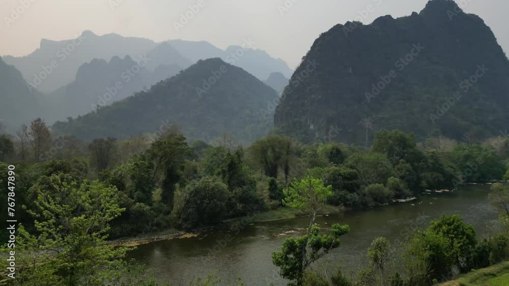 Flying the drone over the trees in Laos, capturing an amazing aerial view of the mountains ahead Flying the drone over the trees in Laos, capturing an amazing aerial view of the mountains ahead
