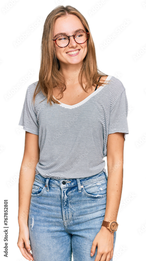 Obraz premium Beautiful young blonde woman wearing casual clothes and glasses looking away to side with smile on face, natural expression. laughing confident.