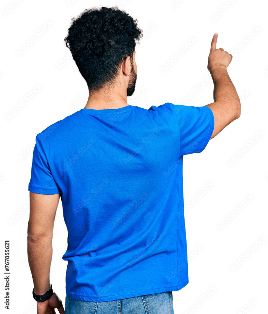 Young arab man with beard wearing casual blue t shirt posing backwards pointing ahead with finger hand Young arab man with beard wearing casual blue t shirt posing backwards pointing ahead with finger hand