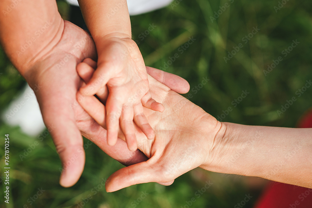 Horizontal photo. Hands of members of the family lying on top of each other. Love, togetherness, happiness in family concept. Copy space for text Horizontal photo. Hands of members of the family lying on top of each other. Love, togetherness, happiness in family concept. Copy space for text