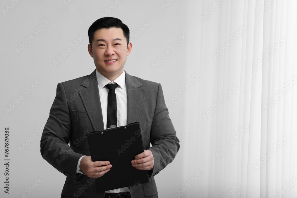 Portrait of happy notary with clipboard indoors, space for text Portrait of happy notary with clipboard indoors, space for text