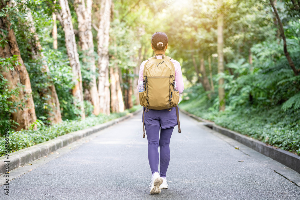 Back view of woman hiking with backpack outdoors Back view of woman hiking with backpack outdoors