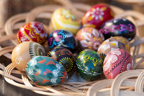Traditional Lithuanian wooden colorful Easter eggs in a wicker basket, symbol of fertility and life painted with the symbols of nature