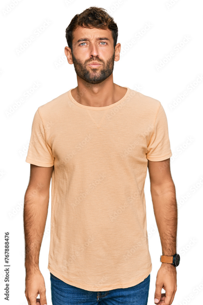 Obraz premium Handsome young man with beard wearing casual tshirt looking at the camera blowing a kiss on air being lovely and sexy. love expression.