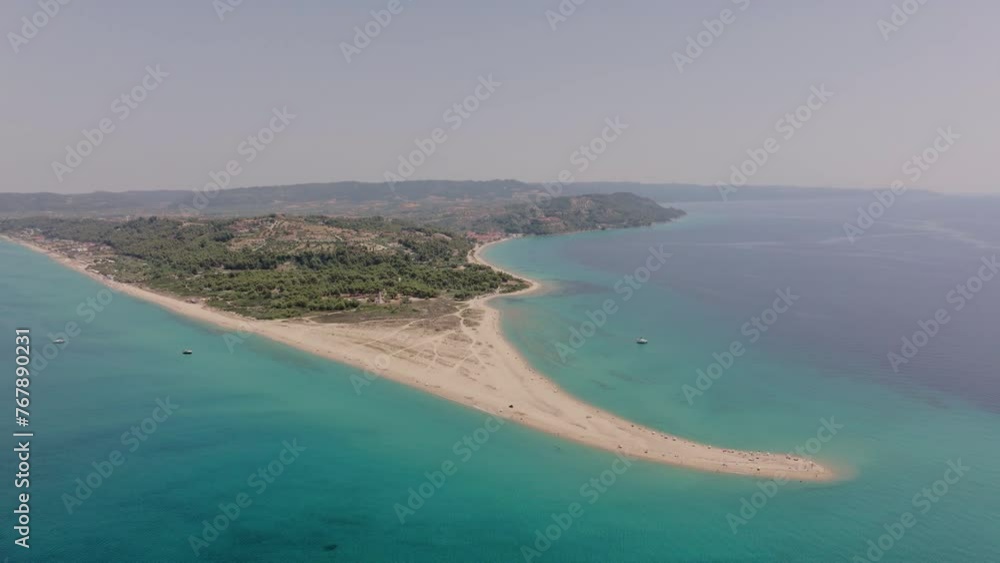Overhead drone records the peninsula of Possidi Cape, Halkidiki, Greece, with clear turquoise water around the sandbar and dense greenery along the coastline Overhead drone records the peninsula of Possidi Cape, Halkidiki, Greece, with clear turquoise water around the sandbar and dense greenery along the coastline