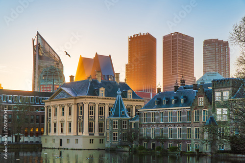 Binnenhof Castle, Mauritshuis museum and the modern skyline of The Hague, the Netherland. Sunrise, yellow sunrays. Clear sky, spring.	