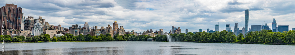 The New York skyline as seen from the lake in Central Park which is a public urban park located in the metropolitan district of Manhattan, in the Big Apple of the United States of America.