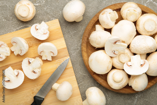 Fresh white champignon mushrooms on cutting board.