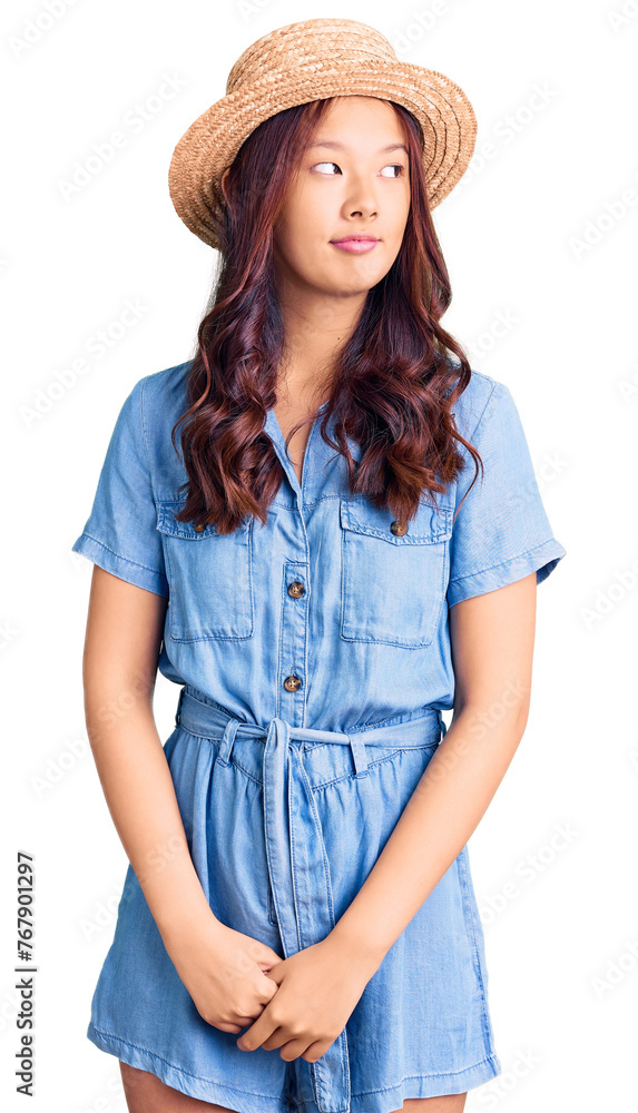 Young beautiful chinese girl wearing summer hat smiling looking to the side and staring away thinking. Young beautiful chinese girl wearing summer hat smiling looking to the side and staring away thinking.