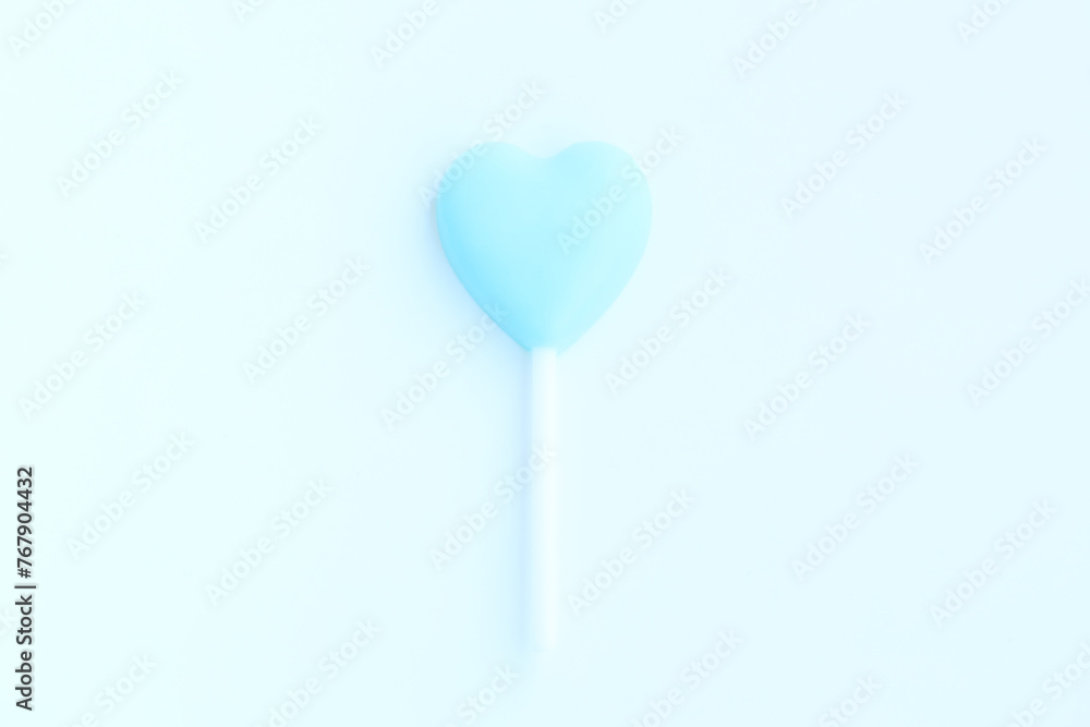 Blue heart shaped lollipop on blue background, Chocolate candy 
