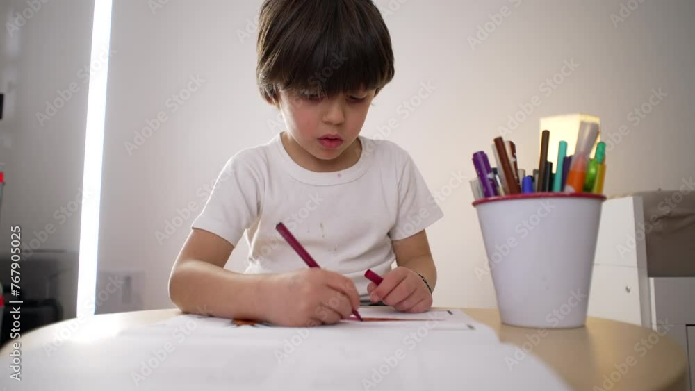 Child drawing on paper with coloring pen. 5-year-old boy engrossed in creative art work, concentrated kid Child drawing on paper with coloring pen. 5-year-old boy engrossed in creative art work, concentrated kid