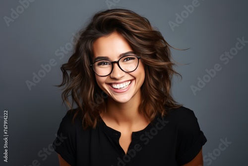 Attractive, happy and smiling young woman with brown hair wearing glasses, isolated on a plain background 
