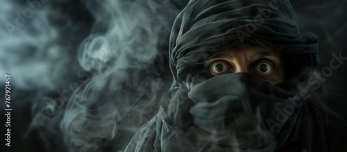 A person's wide eyes gaze through a veil of smoke, adding mystery and intensity to the obscured face.